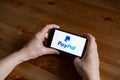 Paypal logo sign application screen on mobile phone online retail service, hands on Royalty Free Stock Photo