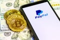 PayPal logo on the smartphone screen against the background of Bitcoin Cryptocurrency Coins. Royalty Free Stock Photo