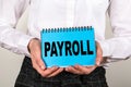 PAYROLL. Salary, bonus and benefits concept. Woman holding blue notebook