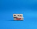 Payroll taxes symbol. Concept word Payroll taxes on wooden blocks. Beautiful blue background. Businessman hand. Business and