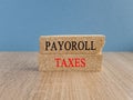 Payroll taxes symbol. Concept words payroll taxes on brick blocks on a wooden tabl