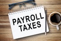 PAYROLL TAXES,Text on notebook in office desk workplace background