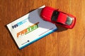 Paytm payment bank issued FASTag RFID contactless cashless payment tag with red model car on a wooden background