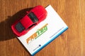 Paytm payment bank issued FASTag RFID contactless cashless payment tag with red model car on a wooden background