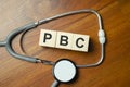 PBC Primary biliary cholangitis - word from wooden blocks with letters on wooden background