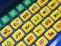PC pocket toy computer for young children keyboard closeup macro. Various simple symbols and shapes on the keys, young kids educat