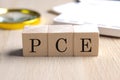PCE- personal consumption expenditure on wooden cubes with magnifier and calculator, financial concept background Royalty Free Stock Photo