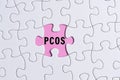 PCOS text on white jigsaw puzzle over pink background. Health Care concept. Royalty Free Stock Photo