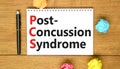 PCS post-concussion syndrome symbol. Concept words PCS post-concussion syndrome on white note on a beautiful wooden background.
