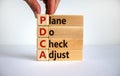 PDCA, plan do check adjust symbol. Wooden cubes and blocks with words `PDCA, plan do check adjust`. Beautiful white background, Royalty Free Stock Photo