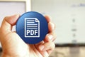 PDF document icon blue round button holding by hand infront of workspace background Royalty Free Stock Photo