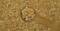 Pea grains in a spoon. Refocusing from a spoonful of grain to a pile of grain. Rotation.