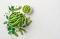 Pea pods and open peas on a gray background with space for copying.