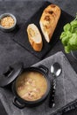 Pea soup with smoked ham in black soucepan on dark background with bread and pepper Royalty Free Stock Photo