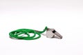 Pea whistle with a green string on white backgroun