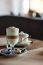 Peace of cake with cup of latte macchiato. Glass of latte coffee and piece of oat cookies. Conceptual delicious sweet Royalty Free Stock Photo