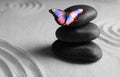 Peace and harmony. Stacked zen garden stones on sand with pattern and beautiful butterfly, space for text Royalty Free Stock Photo