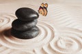 Peace and harmony. Stacked zen garden stones on sand with pattern and beautiful butterfly, space for text Royalty Free Stock Photo