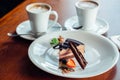 Peace of layered souffle dessert with chocolate sauce on plate, on wooden table Royalty Free Stock Photo