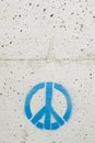 Peace and love symbol painted in blue on a gray concrete wall Royalty Free Stock Photo