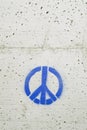 Peace and love symbol painted in blue on a gray concrete wall Royalty Free Stock Photo