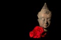 Peace and love. Traditional Buddha head statue with red roses Royalty Free Stock Photo