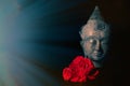 Peace and love. Traditional meditating Buddha head with red roses