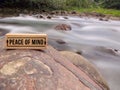 Peace of mind text on wooden block with blurred nature background. Royalty Free Stock Photo
