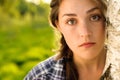 At peace with nature. Shot of a beautiful young woman leaning against a tree in a forest. Royalty Free Stock Photo