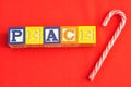 Peace spelled with Alphabet blocks on a red background