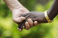 Peace symbol - African and caucasian holding hands together on blurred background