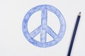 Peace symbol drawn by child with blue pensil on white paper