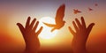Peace symbol with joined hands releasing a birdÃ¢â¬â¢s flight at sunset. Royalty Free Stock Photo