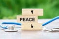 PEACE text on wooden blocks on a green background