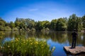 Peace, tranquility and calmness as a boy fishes in the lake on a warm summers day Royalty Free Stock Photo