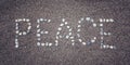 'Peace' word on the sand. Written with pebbles. Aged photo. Royalty Free Stock Photo
