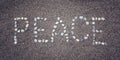 'Peace' word on the sand. Written with pebbles. Aged photo.