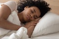 Peaceful African American woman sleeping on soft pillow close up