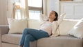 Peaceful attractive woman leaning back, resting on cozy couch