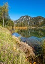 Peaceful autumn Alps mountain lake with clear transparent water and reflections. Almsee lake, Upper Austria