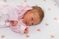 Peaceful baby lying on a bed with heart in a bright room. The baby girl is 15 days old Royalty Free Stock Photo