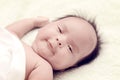 Peaceful baby lying on a bed while sleeping in a bright room