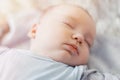 Peaceful baby lying on a bed while sleeping in a bright room Royalty Free Stock Photo