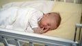 Peaceful baby sleeping on his bed in a room at home.