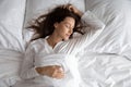 Peaceful beautiful lady relaxing sleeping in cozy bed, top view Royalty Free Stock Photo