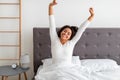 Peaceful black woman stretching arms and back sitting on bed Royalty Free Stock Photo