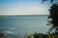 Peaceful blue lake with green grass and blue sky background. Beautiful blue sky and clouds over the reservoir. Rafting activity i Royalty Free Stock Photo