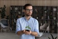 Peaceful businessman hold small green plant look at distance