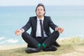 Peaceful businessman sitting in lotus pose relaxing