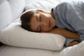 Peaceful calm girl sleeping in soft linen comfortable beddings